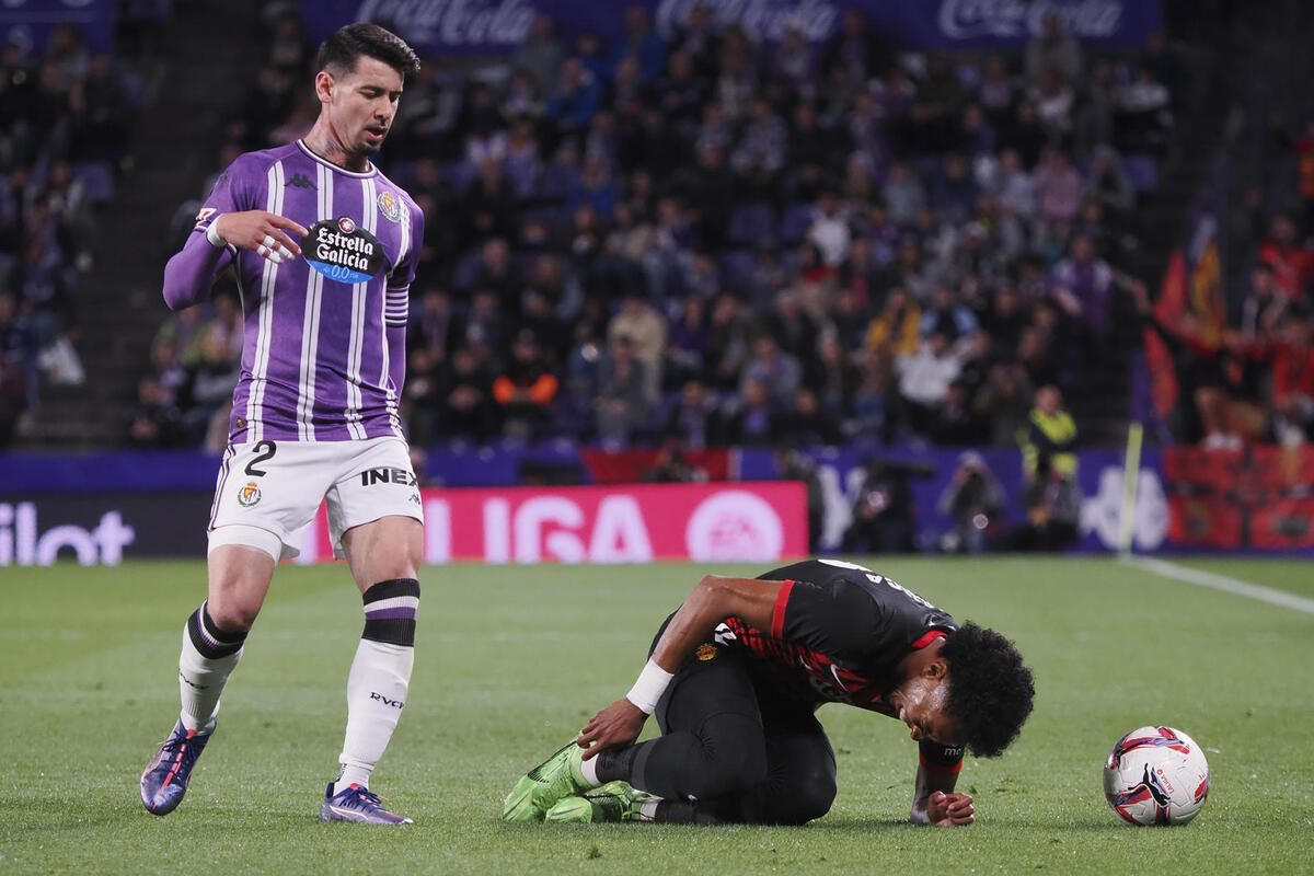 El defensa del Mallorca Johan Mojica (d) en el suelo ante Luis Pérez, del Valladolid, durante el partido de LaLiga en Primera División que Real Valladolid y RCD Mallorca disputan este viernes en el estadio José Zorrilla.   / EFE/ R. GARCÍA