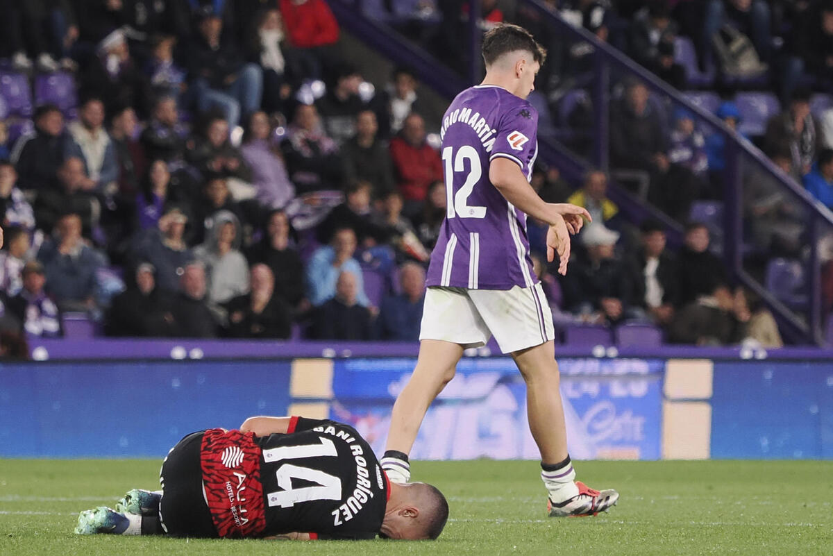 El centrocampista del RCD Mallorca Dani Rodríguez (i) cae al suelo durante el partido de LaLiga en Primera División que Real Valladolid y RCD Mallorca disputan este viernes en el estadio José Zorrilla.  / EFE/ R. GARCÍA