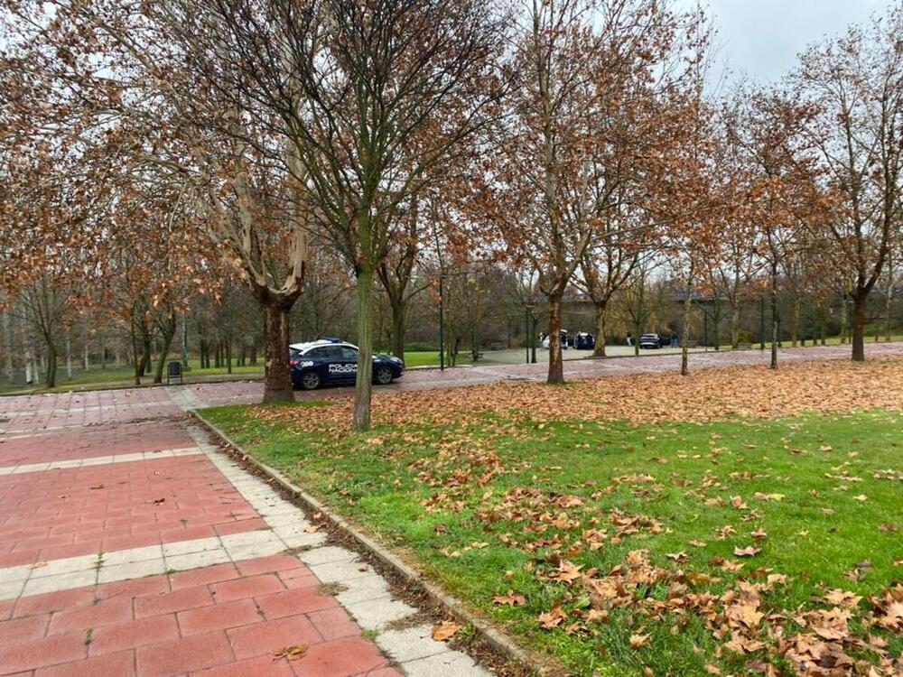 Imagen de vehículos de la Policía junto al puente del Cabildo en uno de los márgenes del río Pisuerga.