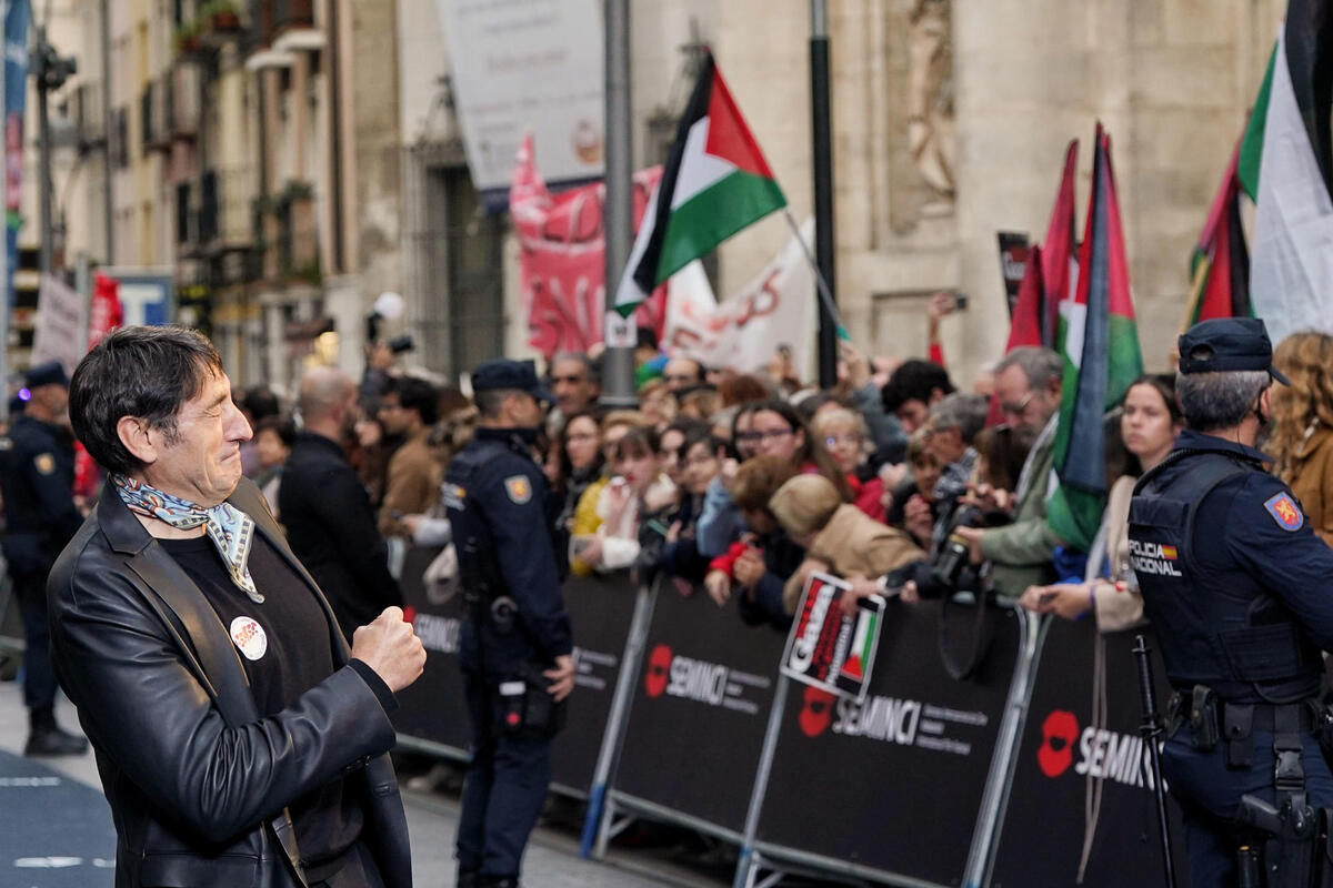 El actor Carmelo Gómez saluda a los manifestantes a favor de Palestina que se han concentrado en la alfombra.  / EFE