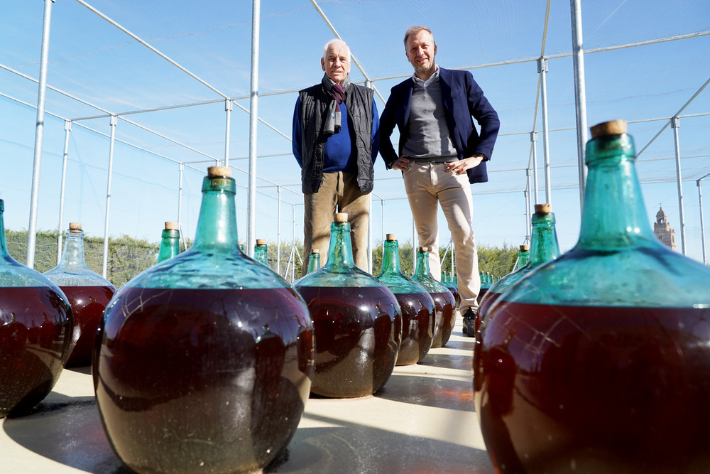 . Félix Lorenzo Cachazo (I) y su hijo Eduardo Lorenzo (D), de la bodega Félix Lorenzo Cachazo, en Pozaldez (Valladolid), junto a las damajuanas de los 'vinos generosos'.