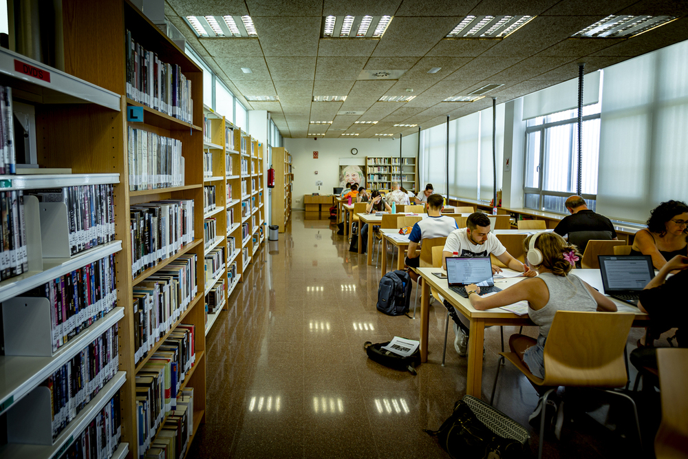 Estudiantes en biblioteca municipal Gloria Fuertes en centro cívico Canal de Castilla estudiando.