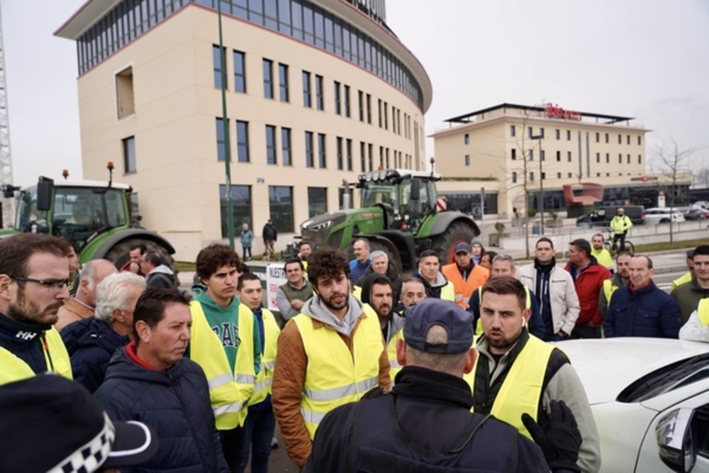 Un grupo de agricultores habla con un agente de la Policía Nacional. 